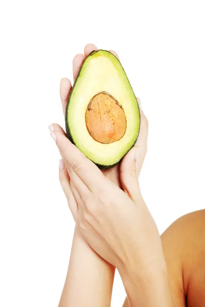 Hübsche weibliche Hände mit frischer Avocado — Stockfoto