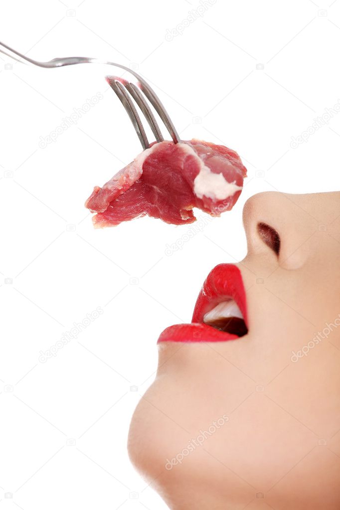 Young beautiful woman eating raw meat