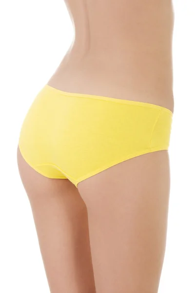 Slim tanned woman's body in yellow panties. — Stock Photo, Image