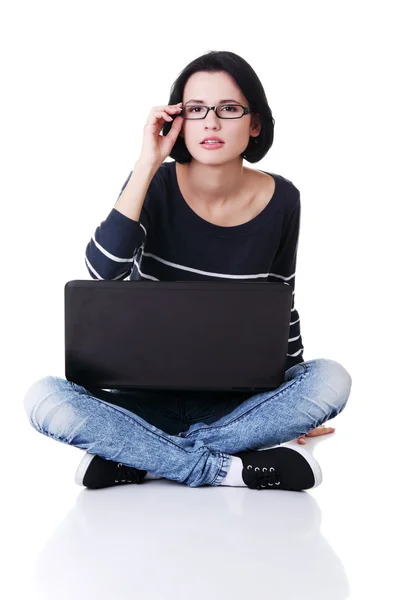 Joven mujer reflexiva con un ordenador portátil — Foto de Stock