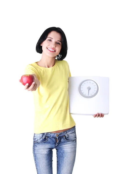 Mujer joven sosteniendo escamas y manzana — Foto de Stock