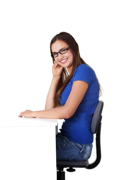 Chica estudiante sonriente sentada en el escritorio — Foto de Stock