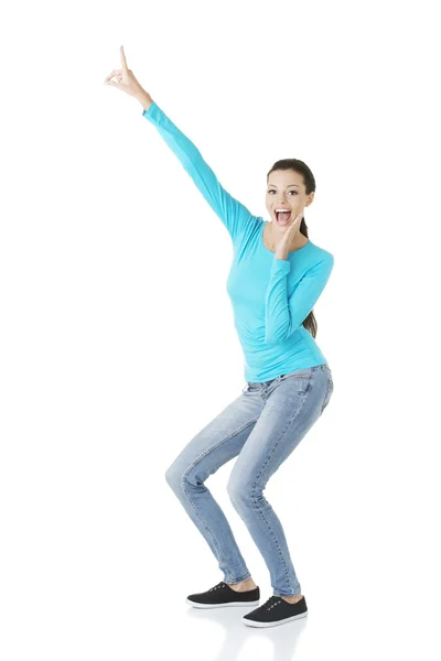 Excited young woman pointing on copy space — Stock Photo, Image