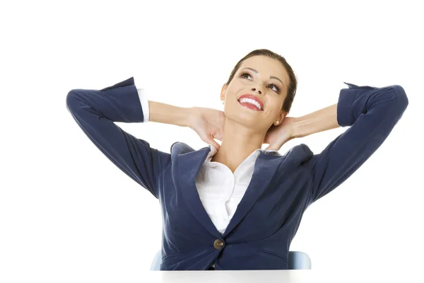 Executive femminile rilassante con le mani dietro la testa — Foto Stock