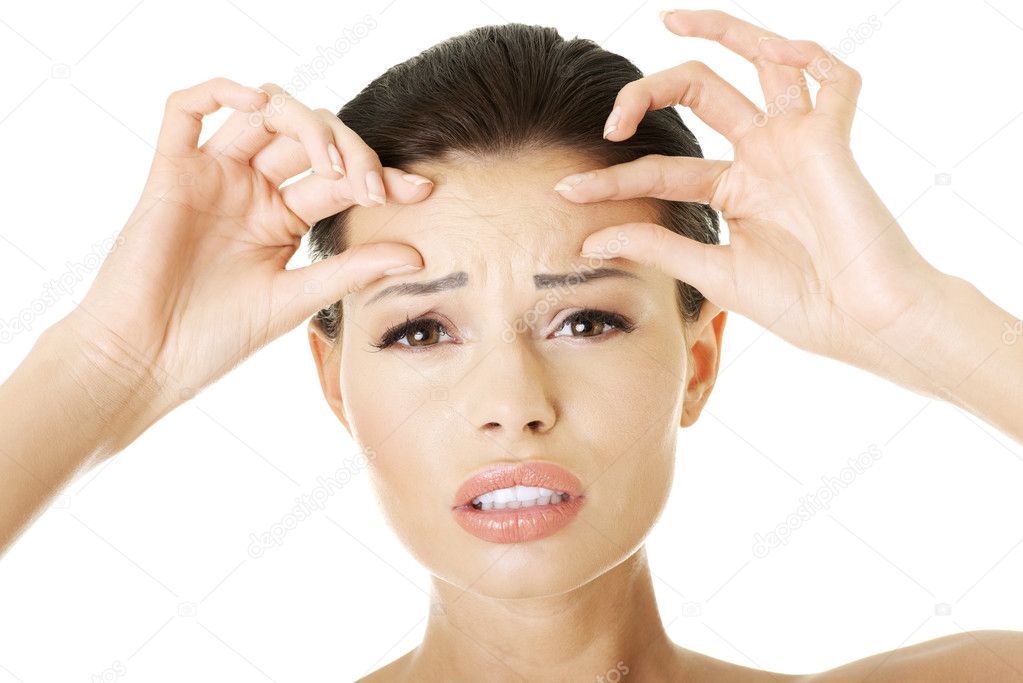 Woman checking her wrinkles on her forehead