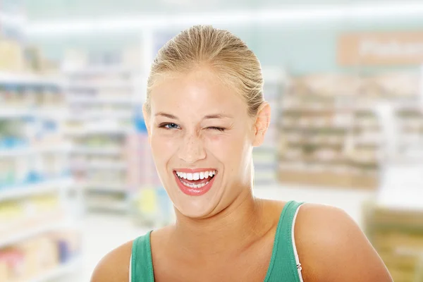 Happy young blond woman blinking.