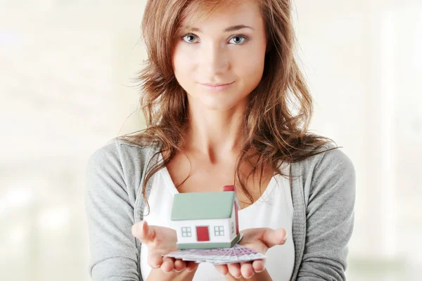 Woman holding euros bills and house model — Stock Photo, Image