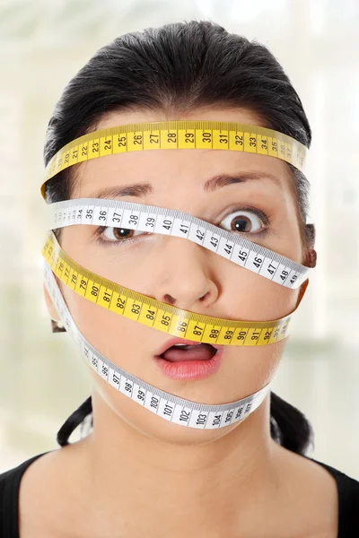 Woman with measuring tape around her head — Stock Photo, Image