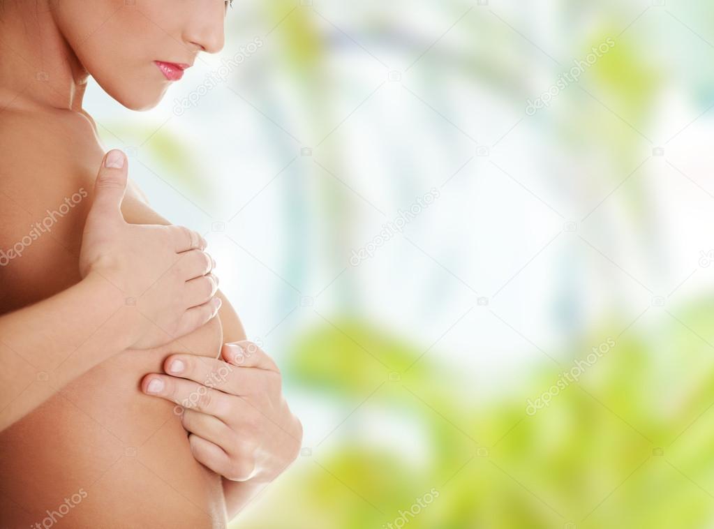 Caucasian adult woman examining her breast