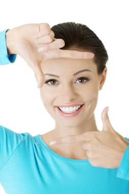 Gülümseyen kadın elleriyle kare kare gösteriyor..