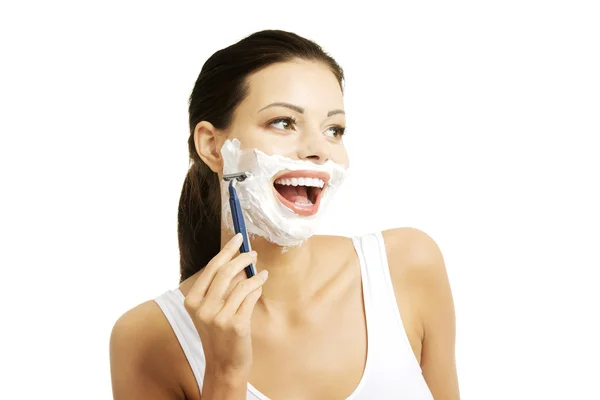 Beautiful young woman shaving her face — Stock Photo, Image