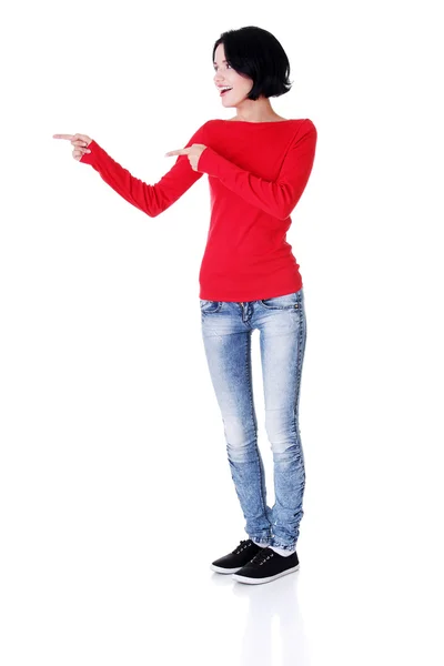 Mujer joven emocionada señalando en el espacio de copia — Foto de Stock