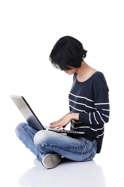 Joven mujer reflexiva con un ordenador portátil — Foto de Stock