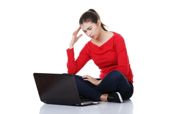 Triest vrouw die op laptop scherm. — Stockfoto