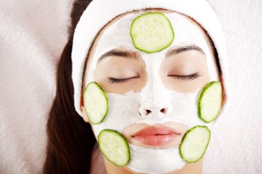 Woman with cucumber slices on the face clipart