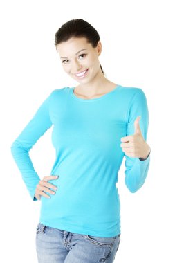 Gayri resmi giyinmiş güzel genç bir kadın başparmağıyla işaret ediyor..