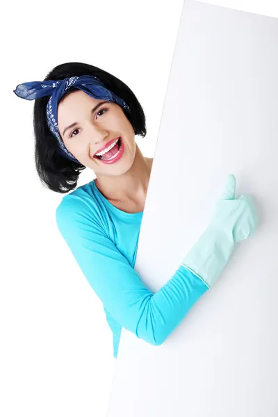 Happy cleaning woman showing blank sign board. — Stock Photo, Image