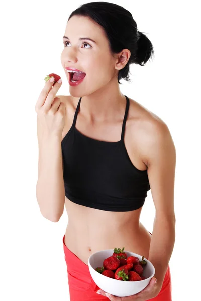 Mulher muito apta a comer morangos — Fotografia de Stock