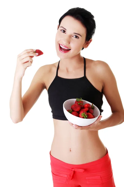 Pretty fit woman eating strawberries — Stock Photo, Image