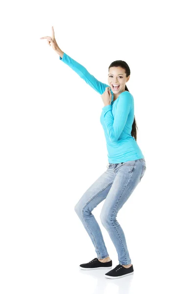 Fröhliche, aufgeregte junge Frau zeigt auf Kopierraum — Stockfoto