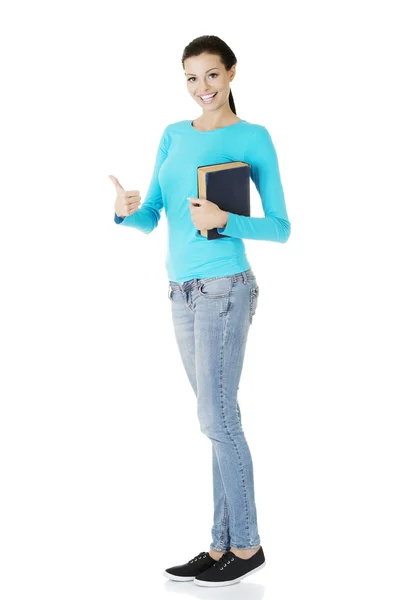 Jovem estudante com livro gesticulando OK — Fotografia de Stock