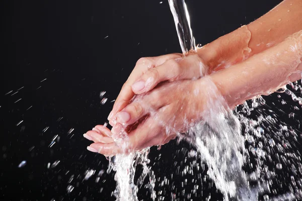 Eau tombant sur les mains féminines — Photo