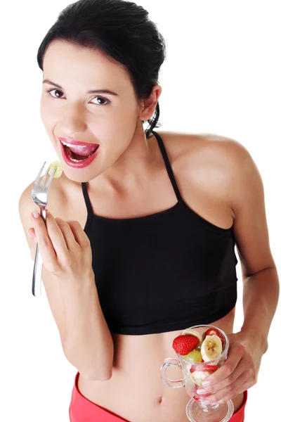 Pretty fit woman eating fruit salad — Stock Photo, Image