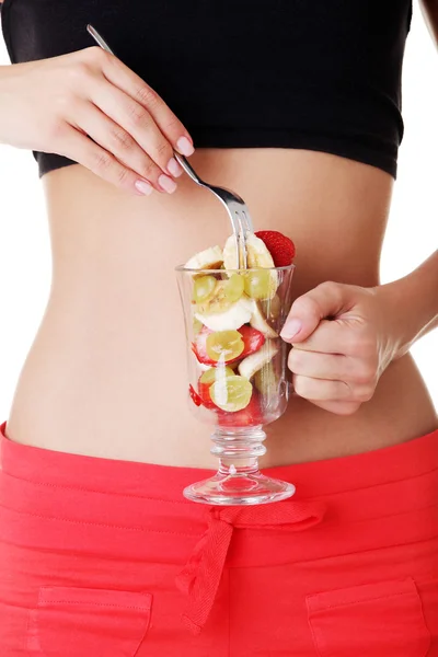 Pretty fit woman belly and fruit salad — Stock Photo, Image