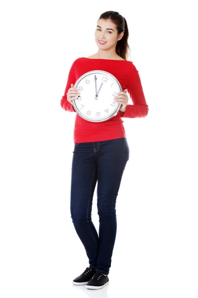 Szczęśliwa młoda kobieta trzyma urząd zegar — Zdjęcie stockowe