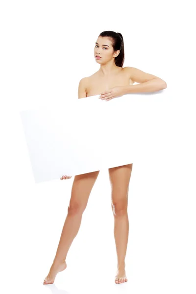 Sexy nahá bruneta drží prázdná deska — Stock fotografie