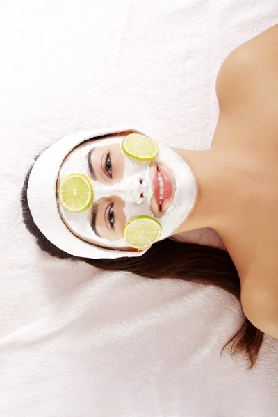 Aantrekkelijke jonge vrouw met vruchten masker op een gezicht — Stockfoto