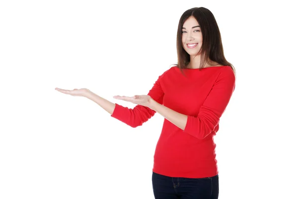 Mujer joven emocionada presentando espacio de copia — Foto de Stock