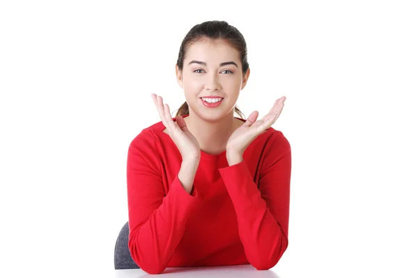 Young woman in casual clothes sitting at the desk — Stock Photo, Image