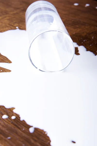 Milk spilled from glass — Stock Photo, Image