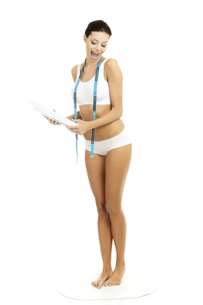 Женщина с измерительной лентой и весами — стоковое фото