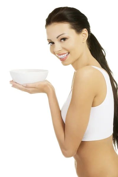 Attractive fit woman holding white bowl — Stock Photo, Image