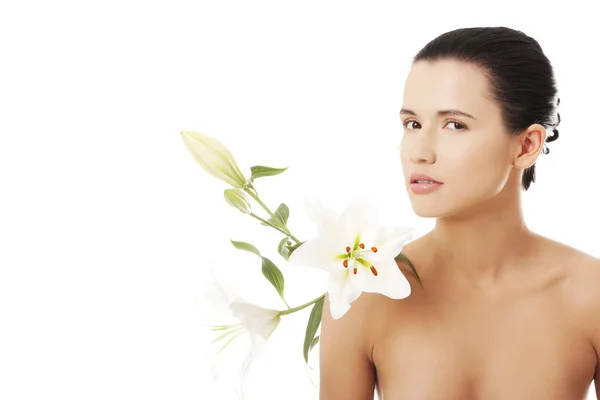 Jeune femme avec la peau de santé et avec la fleur de lis — Photo