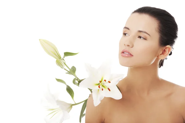 Jonge vrouw met gezondheid huid en met lily bloem — Stockfoto
