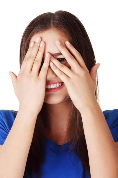 Shy teenage girl peeking through covered face — Stock fotografie