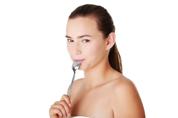Teen girl with spoon in mouth. — Stock Photo, Image