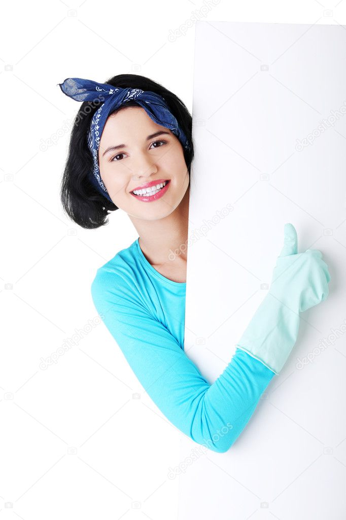 Smiling cleaning woman showing blank sign board.