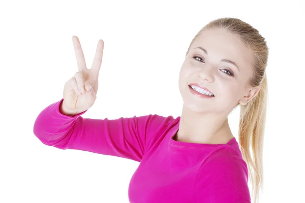 Χαρούμενος νεαρός έφηβος κορίτσι που παρουσιάζει το σήμα της νίκης — Φωτογραφία Αρχείου