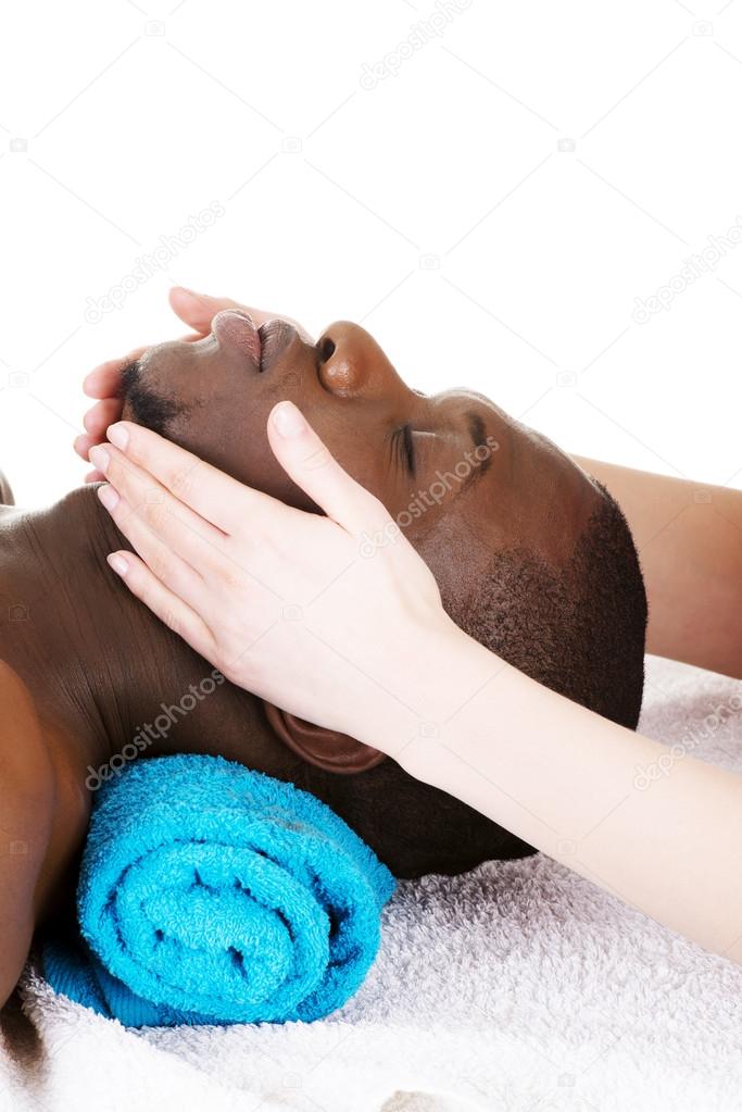 Black man recaiving head massage at spa.