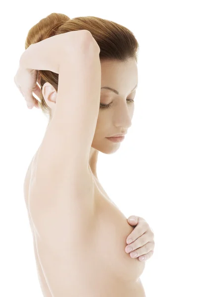 Mulher adulta caucasiana examinando seu peito — Fotografia de Stock