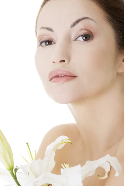 Kvinna med hälsa hud och med lily flower — Stockfoto