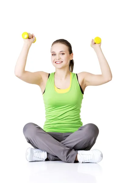 Fitness girl is working out with dumbbells — Stock Photo, Image