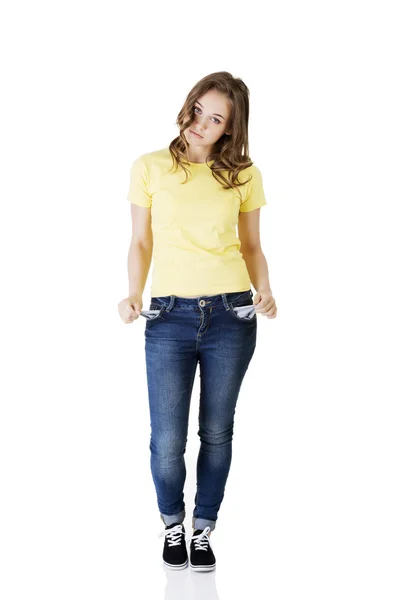 Sad young caucasian teen girl taking out empty pockets — Stock Photo, Image