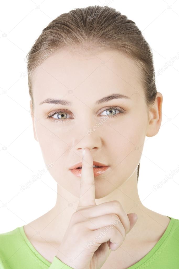 Hush be quiet woman isolated. Teen girl with finger on her lips.