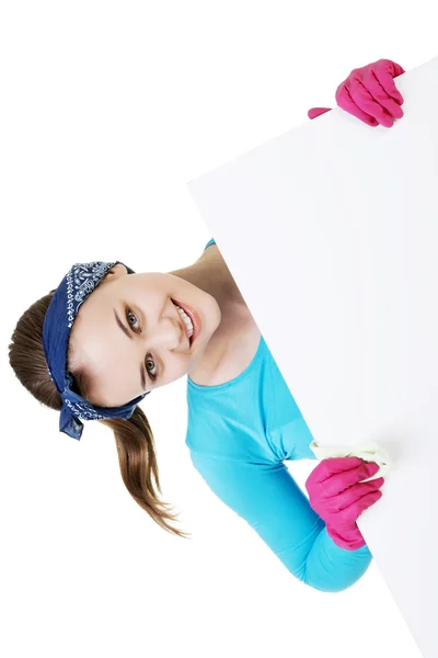 Happy cleaning woman showing blank sign board. — Stock Photo, Image