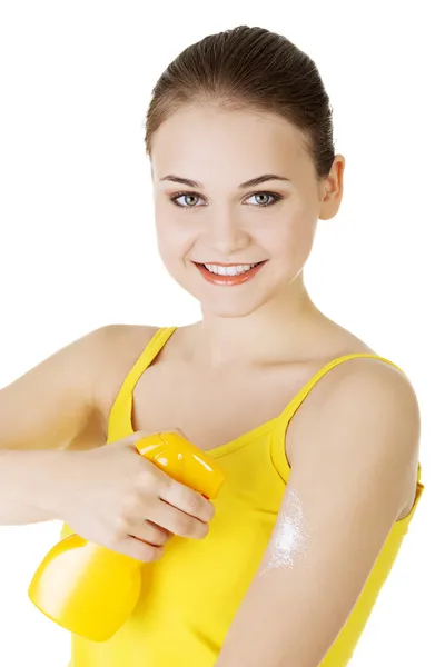 Jonge vrouw met behulp van zonnebrandcrème bescherming. — Stockfoto
